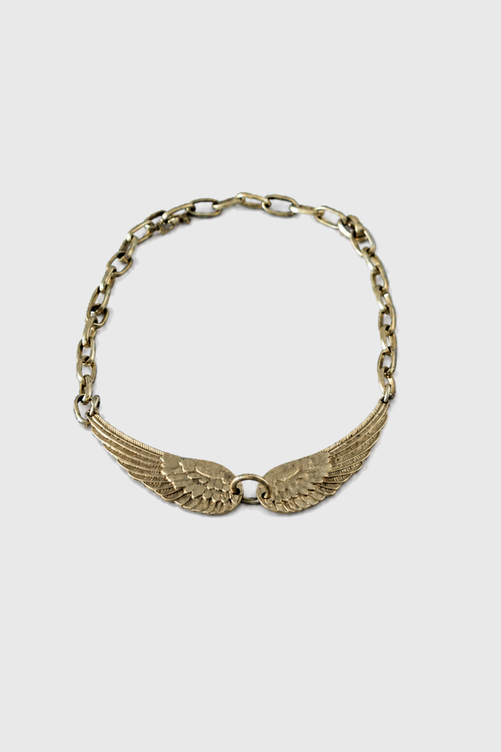 Collar de alas bronce — fondo uniforme #E9E9E9
